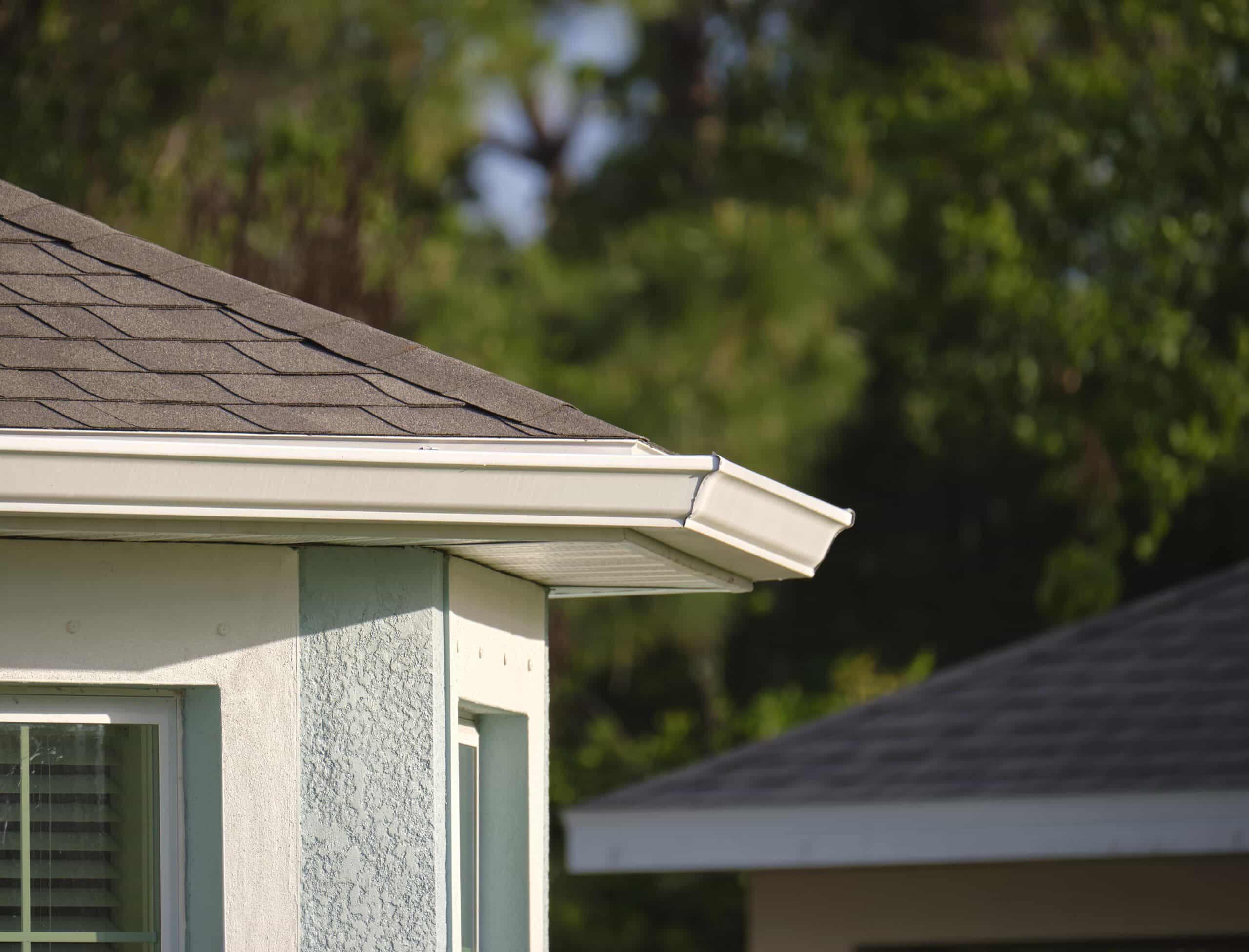 Closeup of house roof top covered with asphalt or bitumen shingles. Waterproofing of new building.
